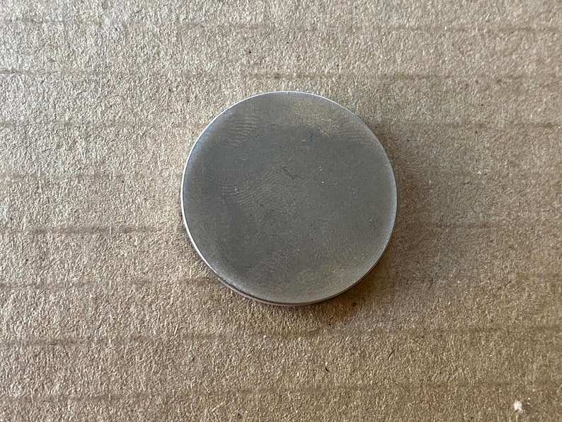 May include: A silver-colored round metal disc.