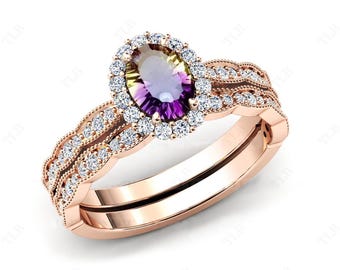 Puede incluir: Un conjunto de anillo de compromiso de oro rosa con una gran piedra preciosa multicolor de forma ovalada rodeada por un halo de diamantes más pequeños. La banda está adornada con un delicado patrón de espiral de diamantes más pequeños.