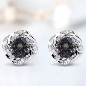 Peut inclure: Une paire de boucles d'oreilles en argent avec une pierre pr&eacute;cieuse noire entour&eacute;e d'un halo de petites pierres blanches.