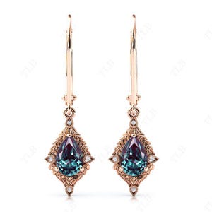 Könnte beinhalten: Ein Paar Ohrringe aus Roségold mit tropfenförmigen grünen und blauen Edelsteinen und kleinen Diamant-Akzenten.