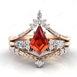 May include: A three-piece ring set featuring a large, red, faceted gemstone in a crown-like setting. The ring is adorned with smaller, clear gemstones.
