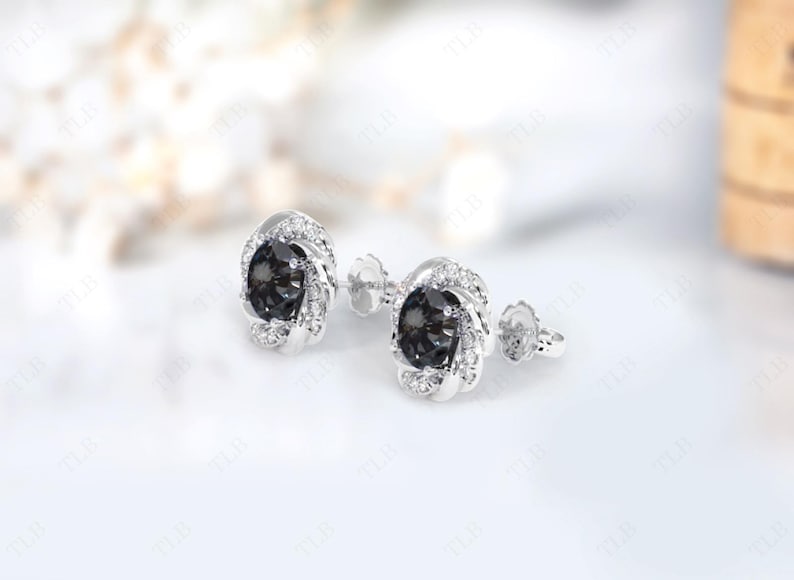 Peut inclure: Une paire de boucles d'oreilles en argent avec une pierre pr&eacute;cieuse noire entour&eacute;e de petites pierres blanches.