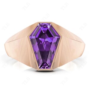Può includere: Un anello in oro rosa con un grande ametista viola sfaccettato incastonato in un design geometrico a punta.