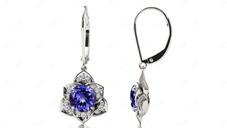 Pu&ograve; includere: Un paio di orecchini pendenti in argento con una pietra preziosa blu circondata da pietre bianche pi&ugrave; piccole a forma di fiore.