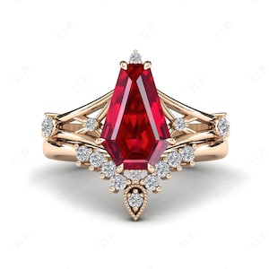 May include: A rose gold engagement ring with a large, red, faceted gemstone surrounded by smaller, clear gemstones.