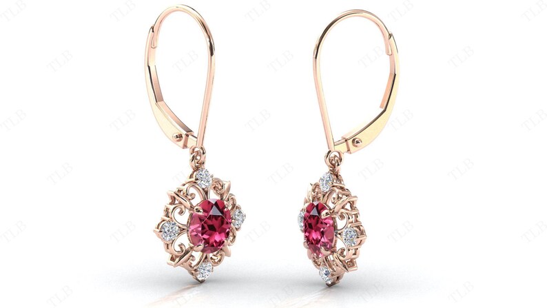 May include: A pair of rose gold dangle earrings with a red gemstone and white gemstones in a floral design.