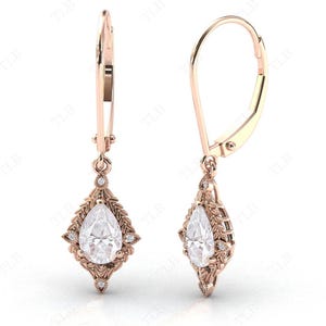 Puede incluir: Un par de pendientes colgantes de oro rosa con piedras preciosas transparentes en forma de pera engastadas en un delicado dise&ntilde;o floral.