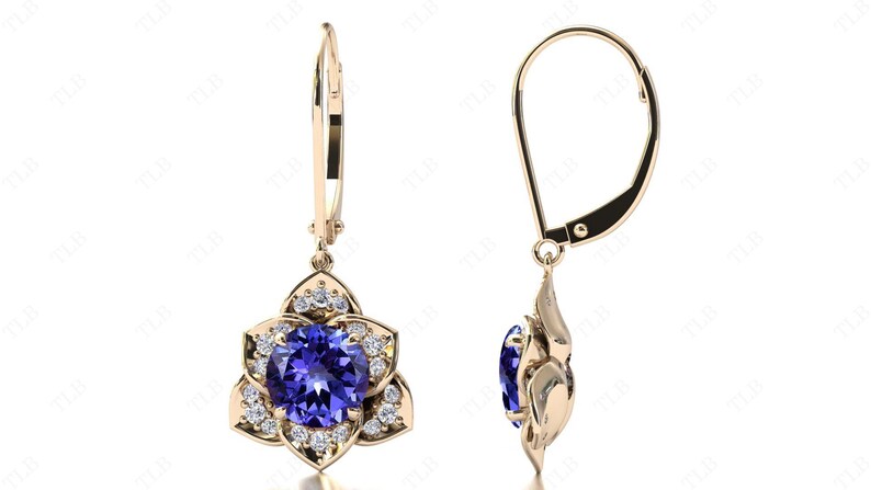 Pu&ograve; includere: Un paio di orecchini pendenti in oro con una pietra preziosa blu circondata da pietre bianche pi&ugrave; piccole a forma di fiore.