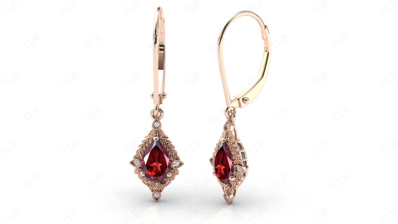 May include: A pair of dangle earrings with a pear-shaped red gemstone surrounded by smaller white gemstones. The earrings are made of gold and have a leverback closure.