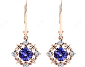 Può includere: Un paio di orecchini pendenti in oro rosa con una pietra preziosa rotonda viola circondata da pietre preziose trasparenti più piccole in un design a filigrana.