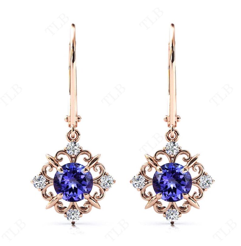 Puede incluir: Un par de pendientes colgantes de oro rosa con una piedra preciosa redonda de color p&uacute;rpura rodeada de piedras preciosas transparentes m&aacute;s peque&ntilde;as en un dise&ntilde;o de filigrana.