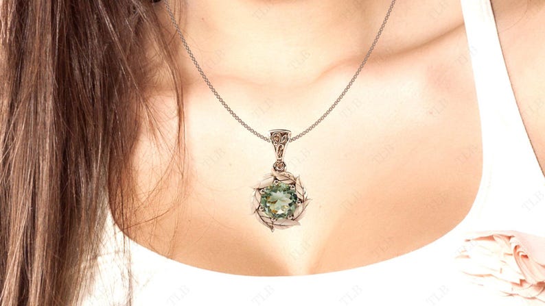 Pu&ograve; includere: Una collana con catena d'argento con un ciondolo di pietra preziosa verde. Il ciondolo &egrave; circondato da un delicato design in argento.