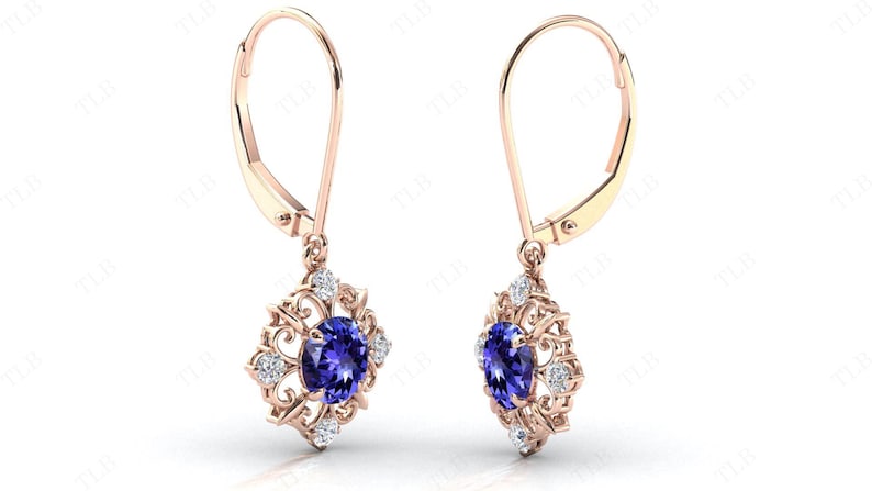 Puede incluir: Un par de pendientes colgantes de oro rosa con una piedra preciosa azul rodeada de piedras blancas m&aacute;s peque&ntilde;as en un dise&ntilde;o de filigrana.