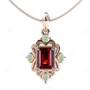 May include: A rose gold pendant necklace with a large red gemstone surrounded by smaller white gemstones. The pendant is in a vintage style with intricate details.