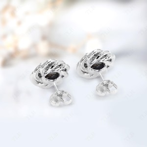 Peut inclure: Une paire de boucles d'oreilles en argent avec un design d&eacute;licat et complexe. Les boucles d'oreilles sont de forme circulaire avec un centre sur&eacute;lev&eacute; et textur&eacute;.