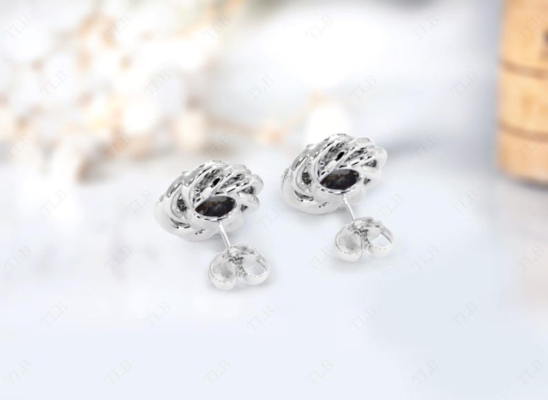 Peut inclure: Une paire de boucles d'oreilles en argent avec un design d&eacute;licat et complexe. Les boucles d'oreilles sont de forme circulaire avec un centre sur&eacute;lev&eacute; et textur&eacute;.