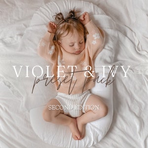 Puede incluir: Una niña pequeña con un suéter rosa con flores blancas y pantalones cortos blancos está durmiendo en una almohada blanca. El texto "VIOLET & IVY preset pack SECOND EDITION" está escrito en la imagen.