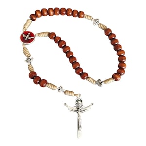 May include: A rosary with dark brown wooden beads and silver-toned crucifix. The beads are connected by a beige cord and silver star-shaped accents. A red and white emblem is also present.