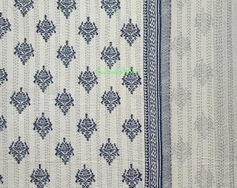Op de afbeelding: Crèmekleurig textiel met een herhalend marineblauw bloemenpatroon. De rand heeft een marineblauw en wit gestreept ontwerp. De stof is waarschijnlijk katoen of linnen, geschikt voor beddengoed of woondecoratie.