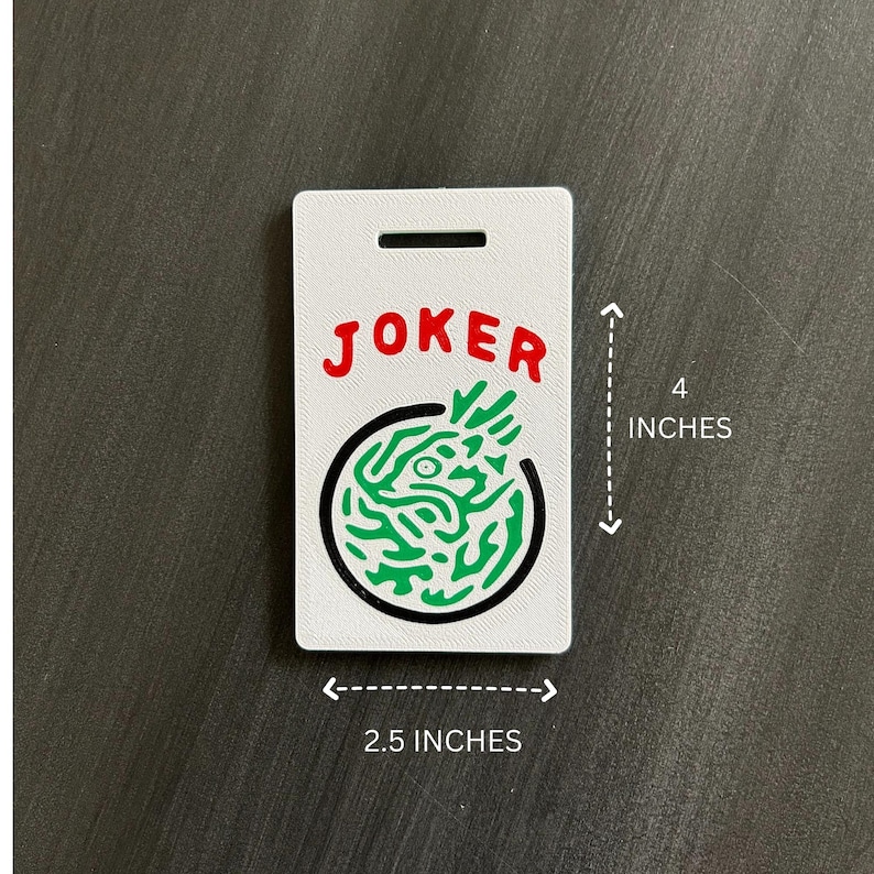 May include: A white rectangular tag with the word "JOKER" in red letters. Below the word is a green and black circular design. The tag is 4 inches tall and 2.5 inches wide.