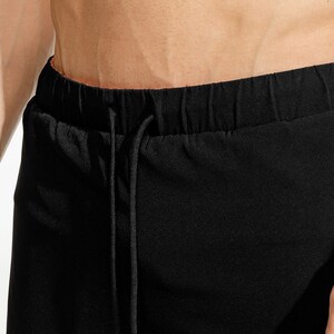 May include: Black drawstring pants with a black drawstring.