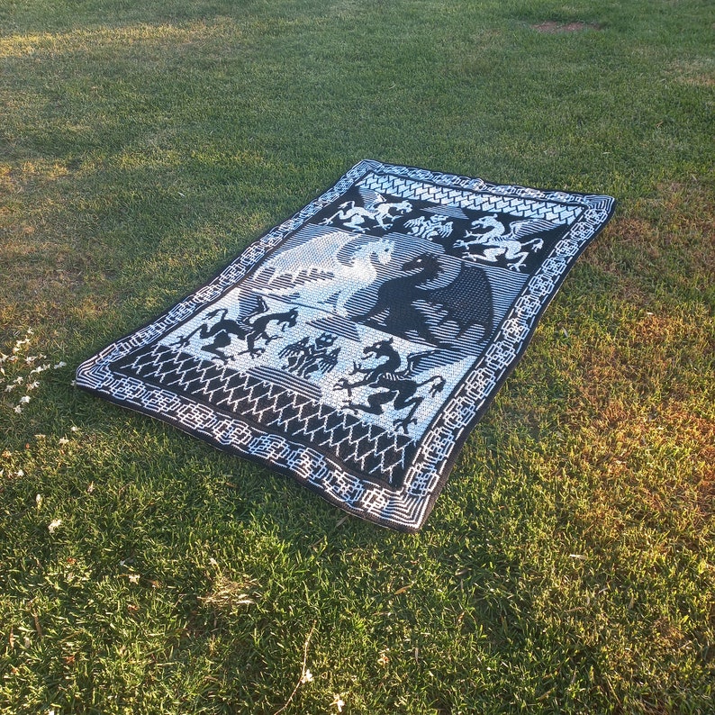 May include: Black and white tapestry featuring a design of dragons and other mythical creatures. The tapestry has a woven texture and a geometric border.