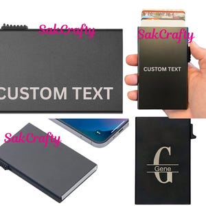 May include: Black metal card holder with "CUSTOM TEXT" printed in white. The holder is shown in multiple views, including one held in a hand, and another with a personalized "G Gene" design. The holder is designed to hold cards.