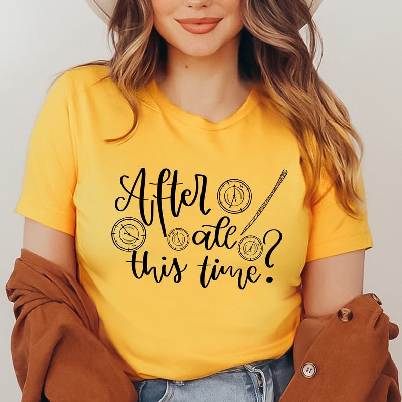 A picture showing a layed out Bella Canvas Unisex 3001 t-shirt in gold color with the words after all this time; in cursive black lettering and with wizard symbols.