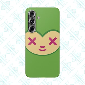 May include: Green phone case featuring a cartoon face with a heart-shaped head, pink 'X' eyes, and a small smile. The case has a green background and a camera module at the top.