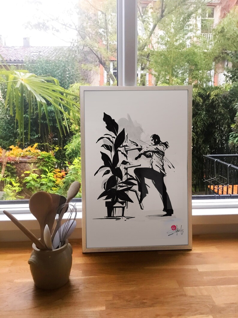 May include: A framed black and white ink drawing of a person climbing a ladder to reach a plant. The drawing is on white paper with a white frame. The drawing is signed in the bottom right corner.