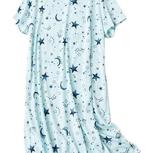 May include: A light blue nightgown featuring a celestial pattern of navy blue stars, crescent moons, and smaller star clusters. The short-sleeved sleep dress is made of a soft, flowing fabric.