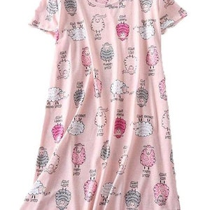 May include: A light pink sleep dress with a pattern of cartoon sheep in various colors and expressions. The sheep are surrounded by text that reads "Lazy Sheep", "Happy Sheep", "Hungry Sheep", and "Singing Sheep".