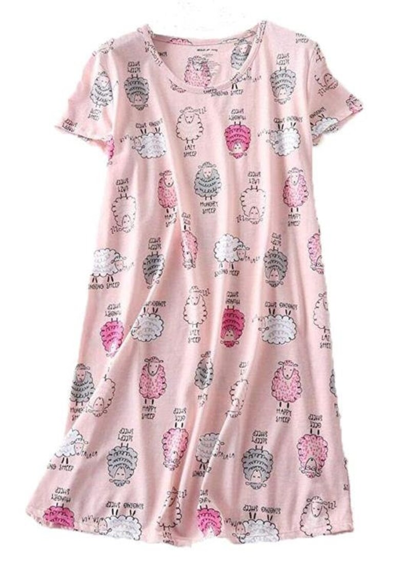May include: A light pink sleep dress with a pattern of cartoon sheep in various colors and expressions. The sheep are surrounded by text that reads "Lazy Sheep", "Happy Sheep", "Hungry Sheep", and "Singing Sheep".