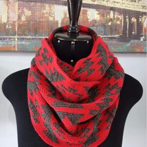May include: Red and brown knitted infinity scarf with a geometric pattern.