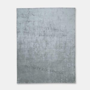 Puede incluir: Un fondo texturizado gris claro con el texto "INFINITY RUGS INDIA" impreso dos veces en negro.