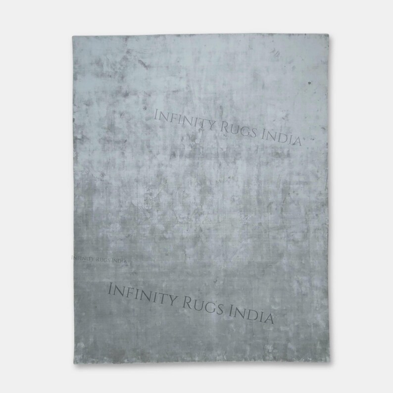 Puede incluir: Un fondo texturizado gris claro con el texto "INFINITY RUGS INDIA" impreso dos veces en negro.