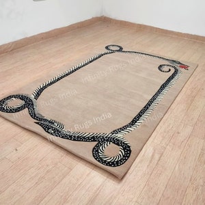 Może przedstawiać: Beżowy dywan z czarno-białym wzorem węża wzdłuż krawędzi. Dywan ma nadrukowany napis "Infinity Rugs India".