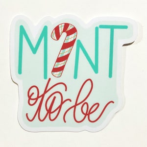 May include: Mint to be sticker with a red and white candy cane graphic on a light blue background.