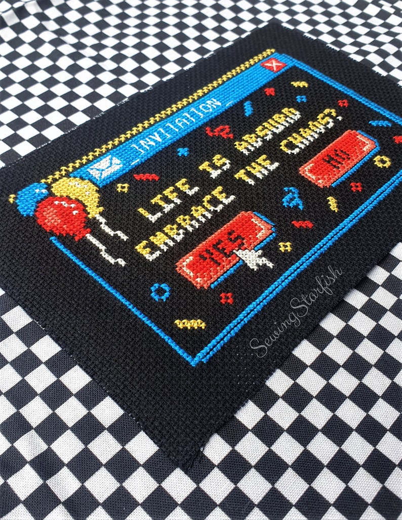 Pode incluir: Padr&atilde;o de ponto cruz de uma tela de computador com o texto "Life is hard, embrace the chaos." com um bot&atilde;o vermelho que diz "Sim" e um bot&atilde;o vermelho que diz "N&atilde;o".