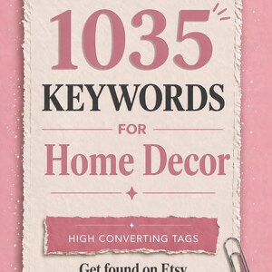 May include: A pink and cream-colored graphic with the text "1035 KEYWORDS FOR Home Decor". The image also includes the text "HIGH CONVERTING TAGS" and "Get found on Etsy faster". A silver paperclip is in the lower right corner.