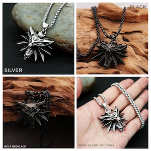 May include: A silver and black wolf pendant necklace with a 24 inch chain. The pendant features a wolf's head with a stylized design. The necklace is available in silver and black.