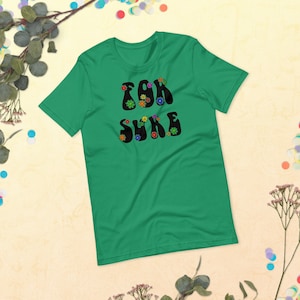 Könnte beinhalten: Ein grünes T-Shirt mit dem Text "for sure" in Schwarz, weiß umrandet, mit bunten Blumen um die Buchstaben.