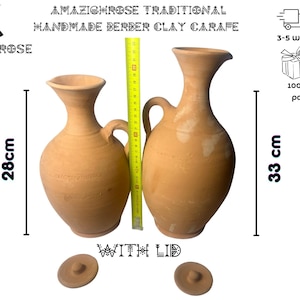 Peut inclure: Deux carafes en terre cuite avec couvercles, l'une mesure 28 cm de haut et l'autre 33 cm. Les carafes sont faites à la main dans un style berbère traditionnel.