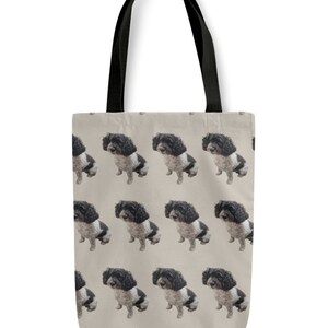 May include: A beige canvas tote bag with black handles features a repeating pattern of a black and white dog. The dog is sitting and looking to the left.