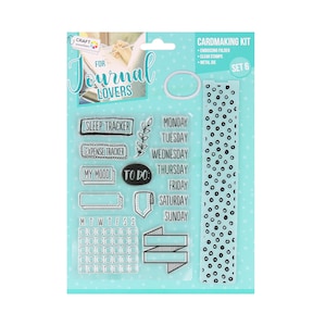 Op de afbeelding: Kaartmakerskit voor journal liefhebbers. Bevat transparante stempels met zinnen als "Sleep Tracker" en "To Do", een kalender en een strook met stippenpatroon. De kit bevat ook een embossing folder en een metalen stans.