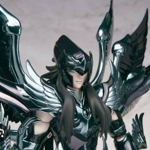 May include: A black and silver action figure of a warrior with long black hair and a helmet. The figure is wearing a detailed armor with wings and a cape.