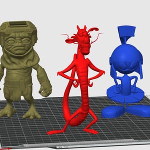 May include: Three 3D-printed figurines: a tan alien-like figure, a red dragon, and a blue cartoon character. The figures stand on a black grid, likely a 3D printer bed. The alien has a helmet and the dragon has a long tail.