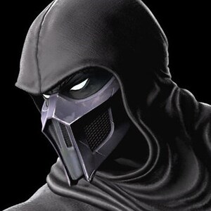 May include: A black hooded figure wearing a silver and black mask. The mask has a sharp, angular design with a grid pattern on the lower portion.