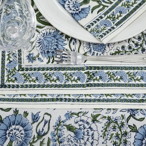 Round blue and white floral hand block printed cotton tablecloth, featuring intricate Indian design with green accents. Perfect dining table cover for farmhouse, cottagecore, or boho decor. Ideal for weddings, housewarming gifts, summer dining, or festive celebrations. Handmade by skilled artisans using traditional block printing techniques. Fits large round tables beautifully, adding elegance to your dining space.