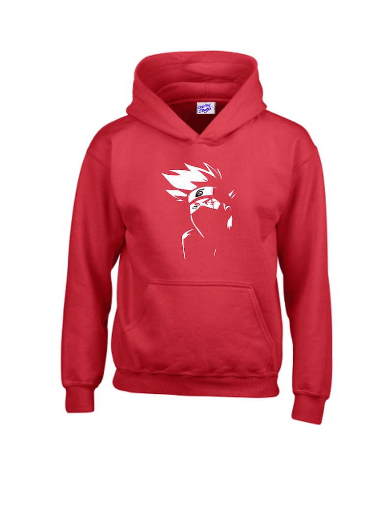 May include: A red hooded sweatshirt with a white graphic of a character from an anime series. The graphic is a stylized illustration of a person with spiky white hair, a headband, and a face covering. The sweatshirt has a kangaroo pocket.
